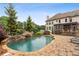 Lush backyard with a freeform pool, rock waterfall feature, and well-maintained patio for outdoor enjoyment at 615 Lovinggood Trl, Woodstock, GA 30189