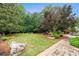 Scenic backyard with lush landscaping, a stone walkway, and mature trees at 615 Lovinggood Trl, Woodstock, GA 30189