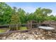 Balcony with stone flooring and wooden railing surrounded by lush trees at 615 Lovinggood Trl, Woodstock, GA 30189
