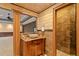 Detailed bathroom with stone floors, wooden cabinets and tiled walk-in shower at 615 Lovinggood Trl, Woodstock, GA 30189
