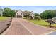 Long brick driveway leading to a grand two-story residence with well-maintained landscaping at 615 Lovinggood Trl, Woodstock, GA 30189