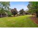 Beautifully landscaped front yard with mature trees and lush green lawn at 615 Lovinggood Trl, Woodstock, GA 30189