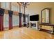 Spacious living room featuring hardwood floors, large windows, a fireplace, and elegant curtains at 615 Lovinggood Trl, Woodstock, GA 30189