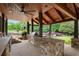 Outdoor kitchen featuring stone counters, a grill, and wood paneled ceiling at 615 Lovinggood Trl, Woodstock, GA 30189