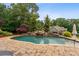 Beautiful pool with waterfall feature, and large brick surround at 615 Lovinggood Trl, Woodstock, GA 30189