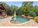 Inviting backyard pool with an outdoor kitchen, stone patio, and a lush lawn for leisure and entertaining at 615 Lovinggood Trl, Woodstock, GA 30189