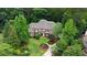 Aerial view of a beautiful brick home surrounded by mature trees and lush landscaping for ultimate privacy and curb appeal at 816 Blackfoot Trl, Suwanee, GA 30024