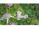 An aerial view of a luxurious home with a pool, surrounded by a lush green lawn and tall trees at 816 Blackfoot Trl, Suwanee, GA 30024