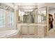 Bright bathroom featuring a soaking tub, walk-in closet access, and natural light at 816 Blackfoot Trl, Suwanee, GA 30024