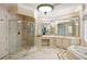 Luxurious bathroom featuring a glass shower, jacuzzi tub, vanity, and decorative tile flooring at 816 Blackfoot Trl, Suwanee, GA 30024
