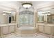 Luxurious bathroom with a soaking tub, separate vanities, and decorative mirrors at 816 Blackfoot Trl, Suwanee, GA 30024