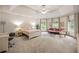 Airy bedroom with carpet floors and a tray ceiling provides a cozy couch for relaxing and large windows at 816 Blackfoot Trl, Suwanee, GA 30024