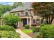 Elegant brick home featuring a charming front porch, balcony, and meticulously maintained landscaping at 816 Blackfoot Trl, Suwanee, GA 30024
