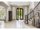Elegant foyer with tile flooring, high ceilings, ornate columns, a curved staircase, and wrought iron detailing at 816 Blackfoot Trl, Suwanee, GA 30024