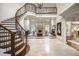 Grand foyer with soaring ceilings, fireplace, staircase with wrought iron railing, and views of a living room at 816 Blackfoot Trl, Suwanee, GA 30024