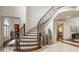 Elegant foyer with a curved staircase, decorative vases, and access to various rooms at 816 Blackfoot Trl, Suwanee, GA 30024