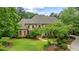 Traditional brick home with a lush front lawn, mature trees, manicured landscaping, and a stone walkway leading to the entrance at 816 Blackfoot Trl, Suwanee, GA 30024