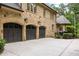 Spacious three-car garage with brick exterior and a large concrete driveway for ample parking at 816 Blackfoot Trl, Suwanee, GA 30024