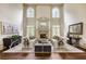 Spacious living room with fireplace, high ceilings, and natural light from large windows at 816 Blackfoot Trl, Suwanee, GA 30024