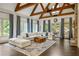 Spacious living room features exposed beams, a stone fireplace, and large windows at 816 Blackfoot Trl, Suwanee, GA 30024