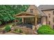 Outdoor patio with stone flooring and a covered area, featuring comfortable seating and dining options at 816 Blackfoot Trl, Suwanee, GA 30024