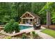 Backyard swimming pool with an adjacent cabana, outdoor seating, and a beautifully landscaped yard perfect for entertaining at 816 Blackfoot Trl, Suwanee, GA 30024
