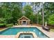 Beautiful backyard pool and pool house surrounded by trees at 816 Blackfoot Trl, Suwanee, GA 30024