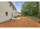 The backyard has a patio, wooden fence, and a sloped lawn covered in pine straw at 3395 The Commons Dr, Cumming, GA 30041