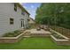 Inviting backyard patio with a built-in seating area and lush landscaping, great for relaxation at 3395 The Commons Dr, Cumming, GA 30041