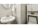 Compact powder room featuring a pedestal sink, modern fixtures, and storage at 3395 The Commons Dr, Cumming, GA 30041