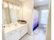Bright bathroom featuring a white vanity with modern lighting and a shower with a stylish purple ombre curtain at 3395 The Commons Dr, Cumming, GA 30041