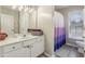 Bathroom featuring a white vanity with a large mirror, and a shower with an ombre curtain at 3395 The Commons Dr, Cumming, GA 30041