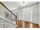 A foyer with hardwood floors, stairs, and a white front door with sidelights at 3395 The Commons Dr, Cumming, GA 30041