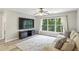 A living room with a large window overlooking the green trees and a mounted TV at 3395 The Commons Dr, Cumming, GA 30041