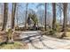 Paver driveway approach to a charming Tudor-style home with mature trees and lion statues at 4210 Gatewood Ln, Peachtree Corners, GA 30097