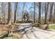 Paver driveway approach to a charming Tudor-style home with mature trees and lion statues at 4210 Gatewood Ln, Peachtree Corners, GA 30097