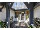 Covered home entrance with stone flooring, ample light, and decorative seating at 4210 Gatewood Ln, Peachtree Corners, GA 30097