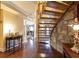 Grand foyer featuring a stone wall, curved staircase, and elegant hardwood floors at 4210 Gatewood Ln, Peachtree Corners, GA 30097