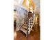Elegant staircase with a unique curved design and stone accent wall at 4210 Gatewood Ln, Peachtree Corners, GA 30097