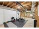 The unfinished basement has a gym with squat rack, weight bench, dumbbells, and treadmill for exercise enthusiasts at 4733 Eidson Road, Dunwoody, GA 30360
