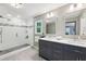 Bright bathroom features a double vanity, glass shower, and large mirrors, offering a luxurious space at 4733 Eidson Road, Dunwoody, GA 30360