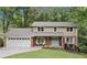 Charming two-story home featuring a brick and siding exterior, a two-car garage, and a welcoming front porch at 4733 Eidson Road, Dunwoody, GA 30360