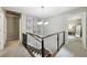 Open hallway with modern cable railing leads to bedrooms and living spaces, illuminated by a chandelier at 4733 Eidson Road, Dunwoody, GA 30360
