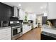 The kitchen is modern with stainless steel appliances, white cabinets, a dark tile backsplash, and wood floors at 4733 Eidson Road, Dunwoody, GA 30360