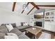 Cozy living room with exposed wood beams, a fireplace, and built-in shelving at 4733 Eidson Road, Dunwoody, GA 30360