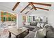 Open-concept living space with exposed beams, a large sectional sofa, and seamless access to sunroom and kitchen at 4733 Eidson Road, Dunwoody, GA 30360