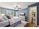 Spacious main bedroom featuring a ceiling fan, a plush king bed, a window and private ensuite access at 4733 Eidson Road, Dunwoody, GA 30360