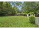 A spacious backyard with lush green grass, bordered by trees and a white picket fence at 484 Culberson Sw St, Atlanta, GA 30310