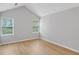 Neutral bedroom featuring bright windows, vaulted ceiling, and hardwood floors at 484 Culberson Sw St, Atlanta, GA 30310