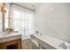 Bright bathroom features a marble countertop, soaking tub, soft lighting, and a large window at 513 Saint Charles Ne Ave, Atlanta, GA 30308